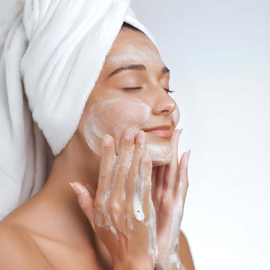 Dame de haar gelaat reinigt met de dubbele schuimende reiniger.